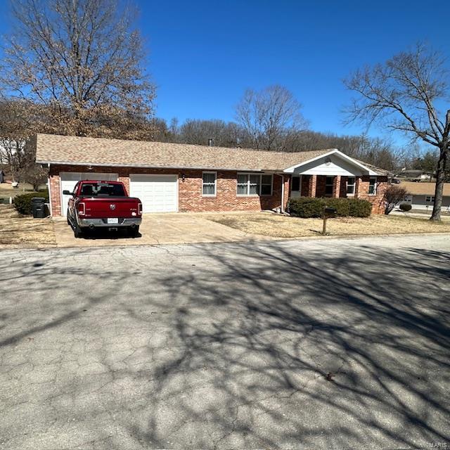 view of front of home featuring brick siding, driveway, and an attached garage