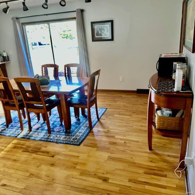 dining area featuring light wood-style floors and baseboards