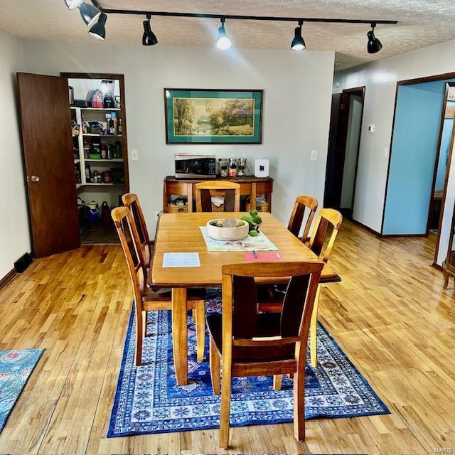 dining area featuring a textured ceiling and light wood-style floors