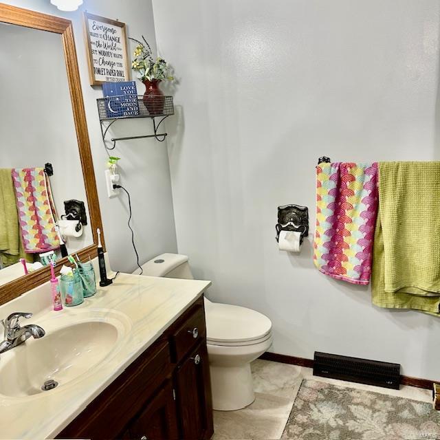 bathroom with vanity, toilet, and baseboards