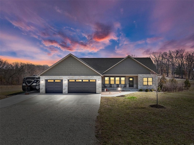 view of front of home featuring a front lawn, a garage, stone siding, and driveway