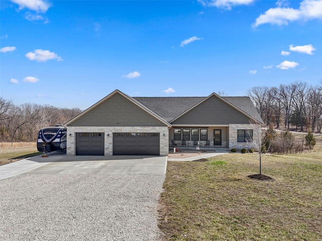 view of front of property featuring a front yard, a garage, stone siding, and driveway