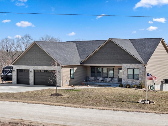 view of front facade featuring stone siding, an attached garage, and driveway