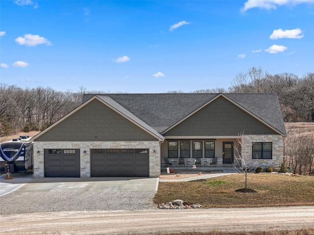 view of front of home with stone siding, driveway, and an attached garage