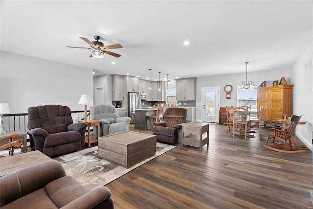 living area with visible vents, ceiling fan with notable chandelier, dark wood finished floors, recessed lighting, and baseboards