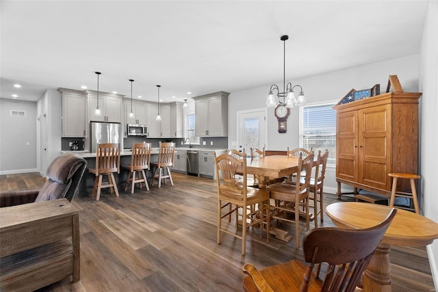 dining area featuring wood finished floors, baseboards, visible vents, recessed lighting, and a chandelier