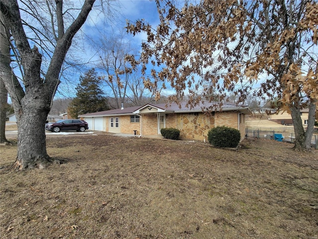 single story home with a garage, brick siding, and a front yard