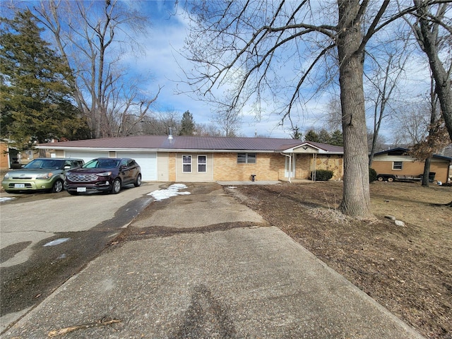 single story home with brick siding, driveway, and an attached garage