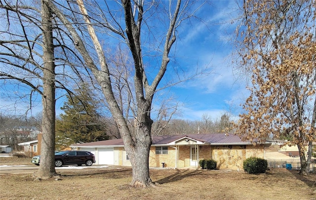 ranch-style home with driveway, brick siding, and an attached garage