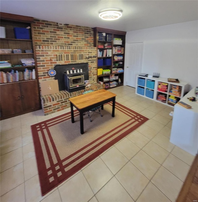 living room with a wood stove and light tile patterned floors