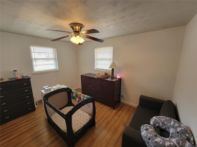 bedroom featuring light wood-style floors, ceiling fan, and baseboards