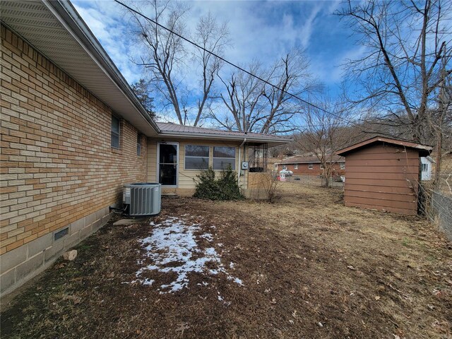 view of yard featuring a storage shed, central AC unit, and an outdoor structure