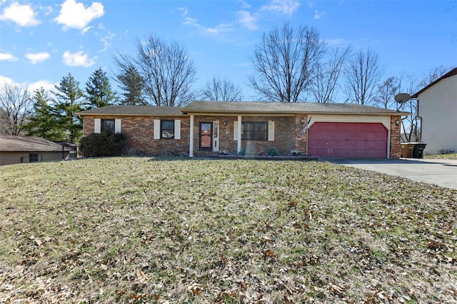 ranch-style home featuring driveway, brick siding, an attached garage, and a front yard