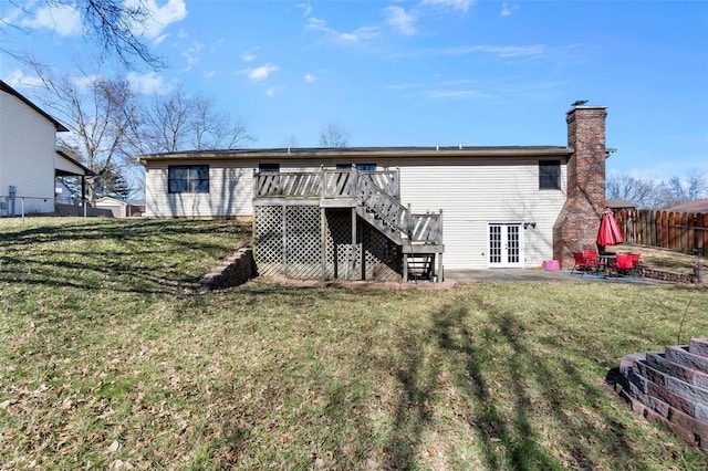 rear view of house with a lawn, french doors, stairs, fence, and a wooden deck