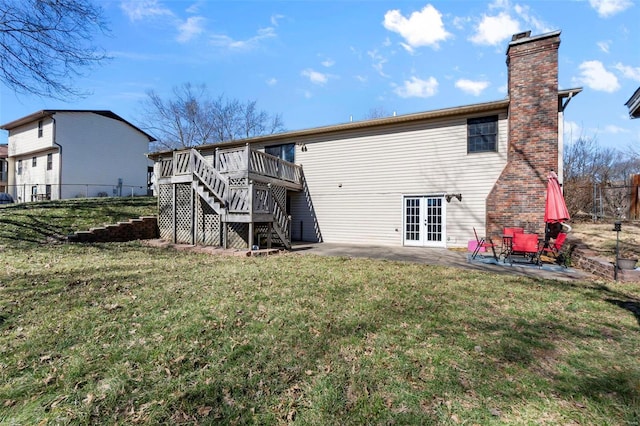 rear view of property with stairs, a patio, french doors, and a lawn