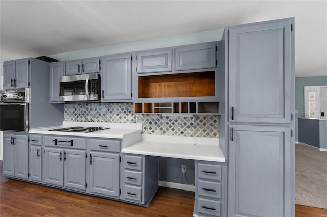 kitchen featuring dark wood finished floors, gray cabinets, light countertops, black appliances, and backsplash