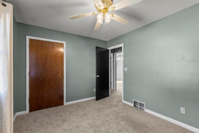 unfurnished bedroom featuring a ceiling fan, carpet, visible vents, and baseboards