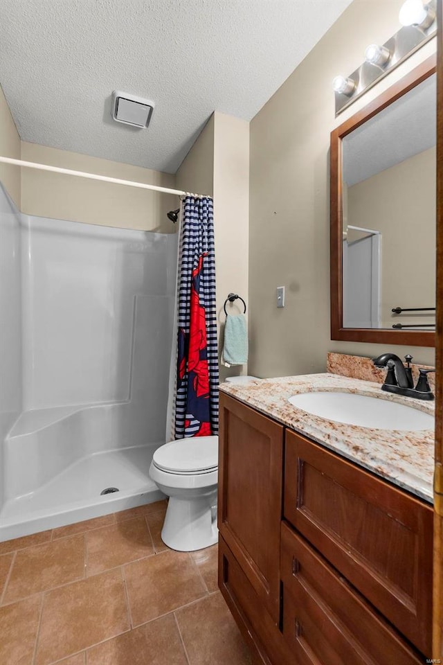 bathroom featuring curtained shower, vanity, toilet, and a textured ceiling