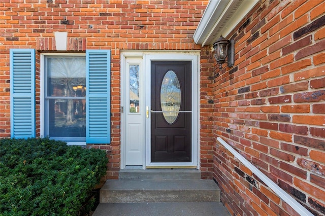 entrance to property featuring brick siding