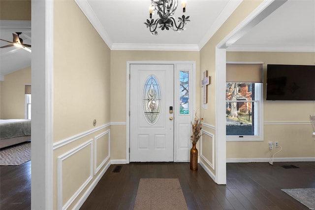 foyer entrance with a healthy amount of sunlight, dark wood-style floors, and crown molding