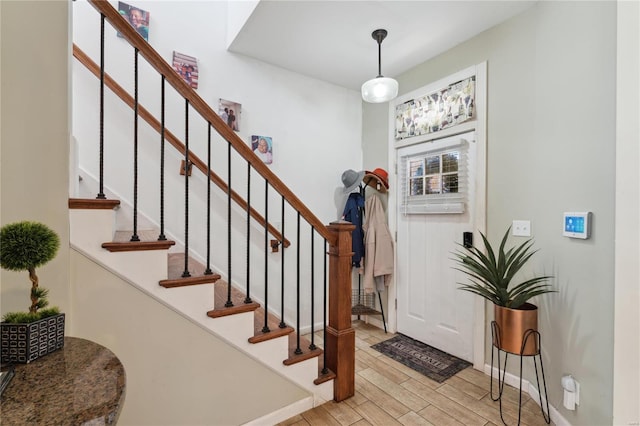 entrance foyer with stairway, light wood-type flooring, and baseboards