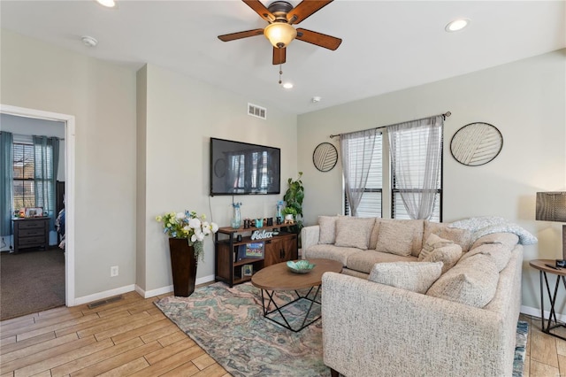 living room featuring recessed lighting, baseboards, visible vents, and light wood finished floors