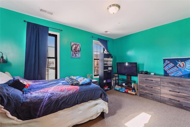 carpeted bedroom featuring visible vents