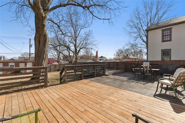 wooden terrace featuring outdoor dining space and a fenced backyard