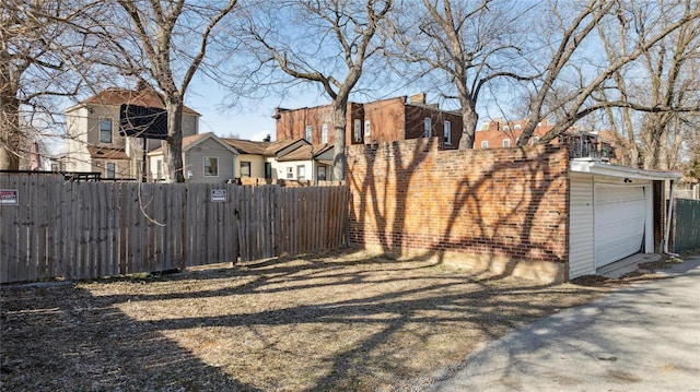 view of yard with a residential view, an attached garage, and fence