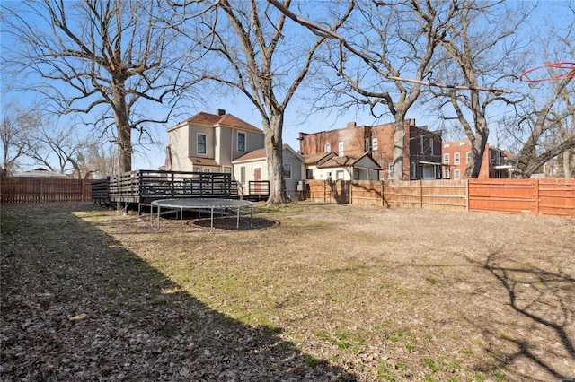 view of yard featuring a fenced backyard, a residential view, and a trampoline