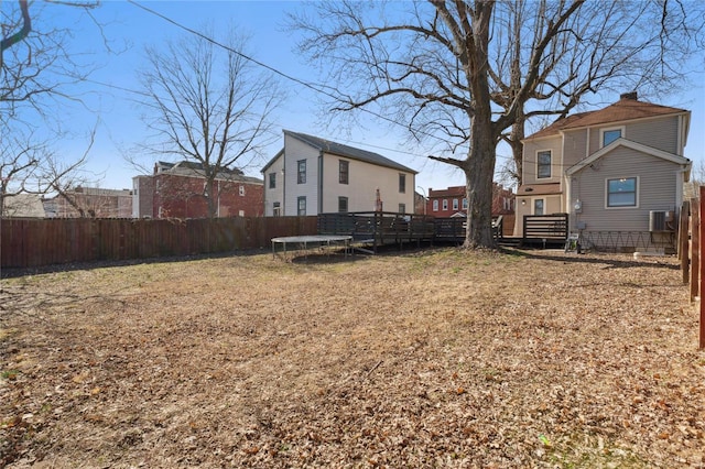 view of yard featuring a trampoline, central AC unit, and a fenced backyard