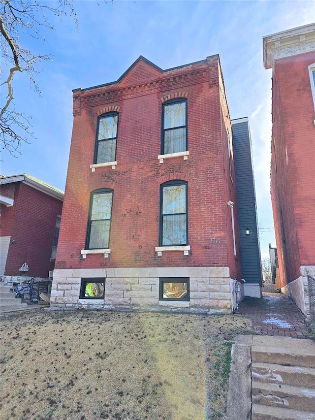 view of front of home featuring brick siding and a front lawn