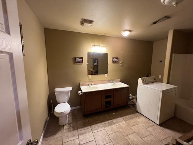 full bathroom featuring washer / clothes dryer, visible vents, toilet, and double vanity