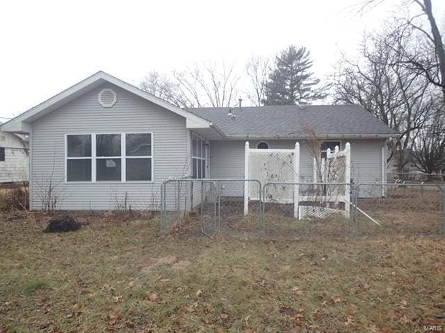 view of front of property featuring a front lawn and fence