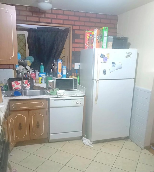 kitchen featuring white appliances, light countertops, a sink, and light tile patterned flooring