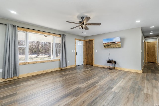 unfurnished living room with ceiling fan, baseboards, wood finished floors, and recessed lighting