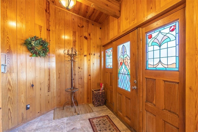 foyer entrance featuring beamed ceiling, wooden ceiling, and wooden walls