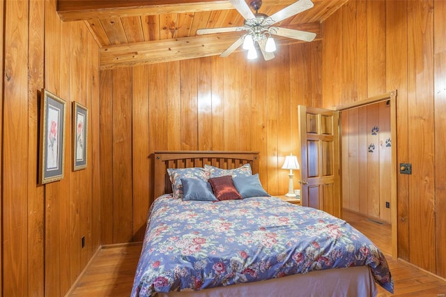 bedroom featuring wooden walls, a ceiling fan, and wood finished floors