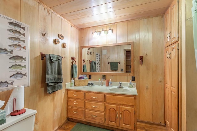 bathroom with toilet, wooden ceiling, wood finished floors, and vanity