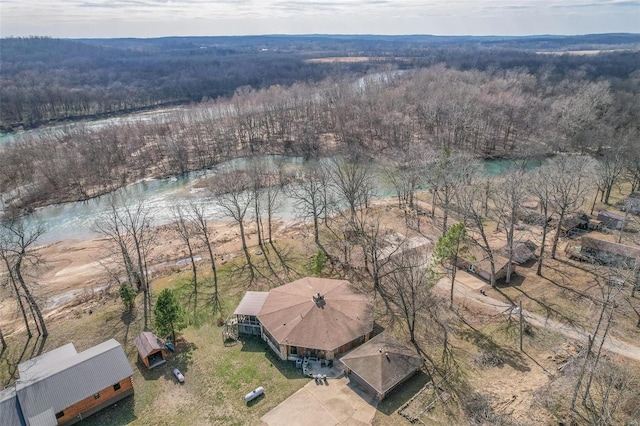 drone / aerial view featuring a forest view and a water view