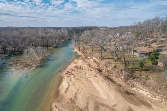 drone / aerial view featuring a water view and a wooded view