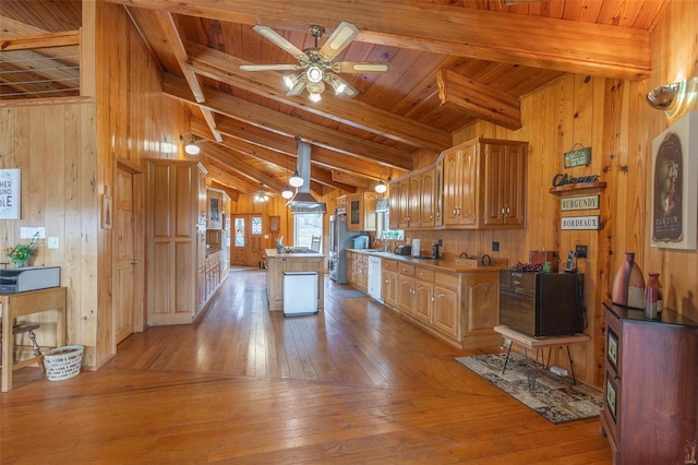 kitchen featuring wood walls, light wood-style flooring, white dishwasher, and a kitchen island