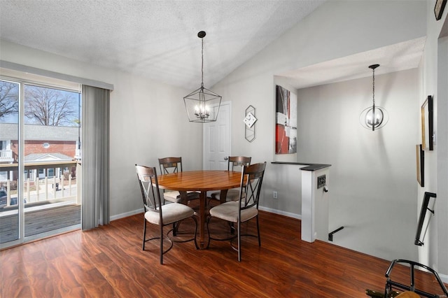 dining space with lofted ceiling, an inviting chandelier, a textured ceiling, and dark wood-type flooring