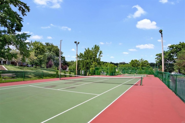 view of tennis court with community basketball court and fence