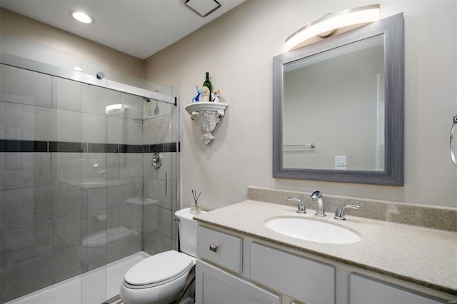 full bathroom featuring toilet, a stall shower, and vanity