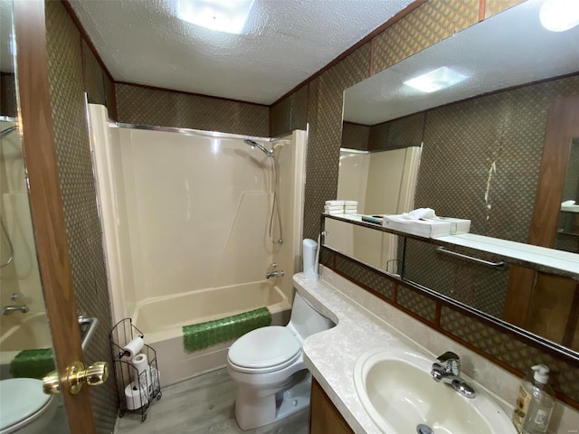 full bathroom featuring toilet, wallpapered walls, shower / washtub combination, and a textured ceiling