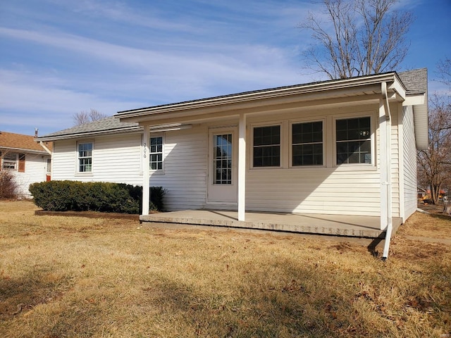 rear view of house featuring a yard and a patio