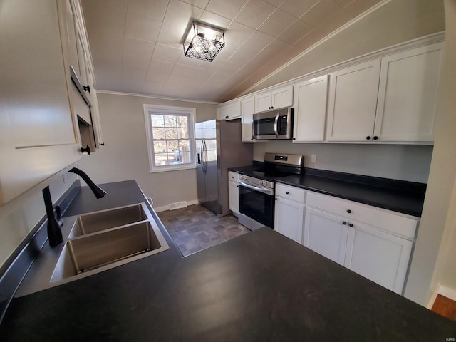 kitchen with stainless steel appliances, dark countertops, a sink, and white cabinets