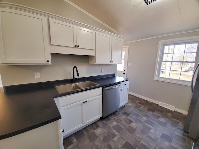 kitchen with dark countertops, ornamental molding, vaulted ceiling, stainless steel dishwasher, and a sink