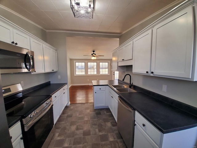 kitchen featuring stainless steel appliances, ornamental molding, dark countertops, and a sink